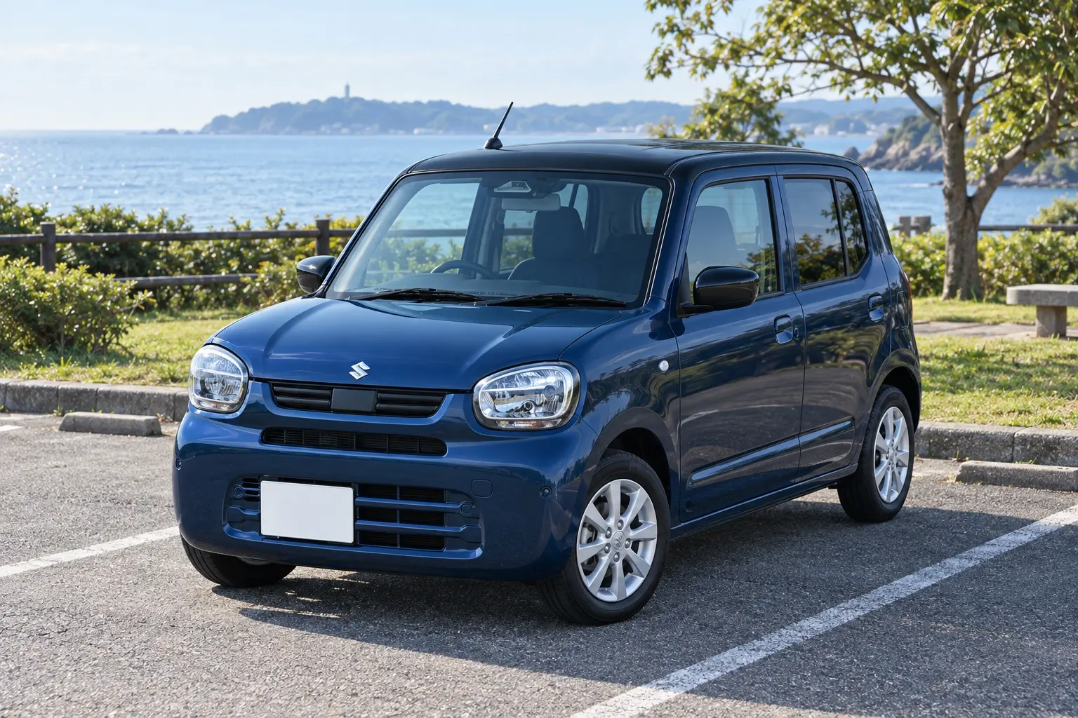 スズキ アルト HYBRID Xの斜め前からの外観。ボディカラーはノクターンブルーパール+ブラックルーフの2トーン。14インチのアルミホイール。海沿いの公園の駐車場に停まっている