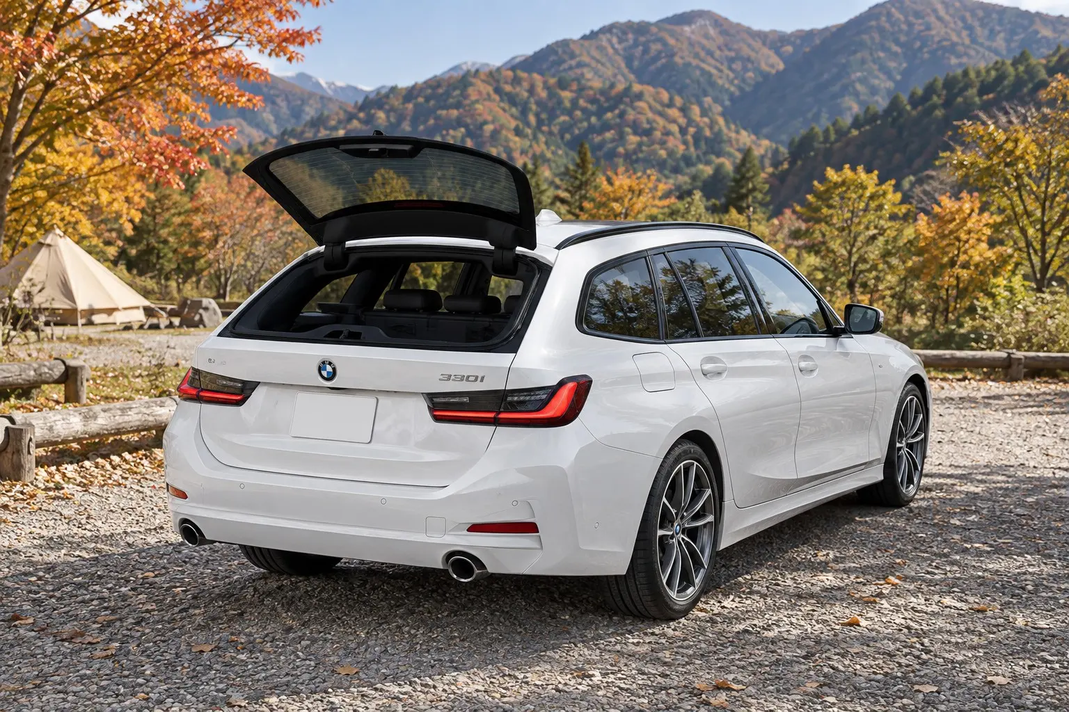 BMW 3シリーズ ツーリング（G21型・改良後）を斜め後ろから見た実車イラスト。ミネラル・ホワイトのボディ、テールゲートのガラスだけを開けた状態、横長のLEDテールランプ。秋の山あいのキャンプ場の駐車場