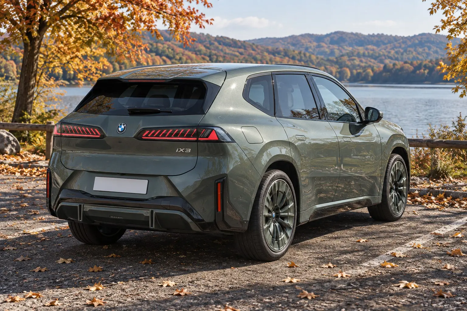 新型BMW iX3を斜め後ろから見た実車イラスト。ユーカリ・グリーンのボディ、細いテールランプ。秋の湖畔の駐車場