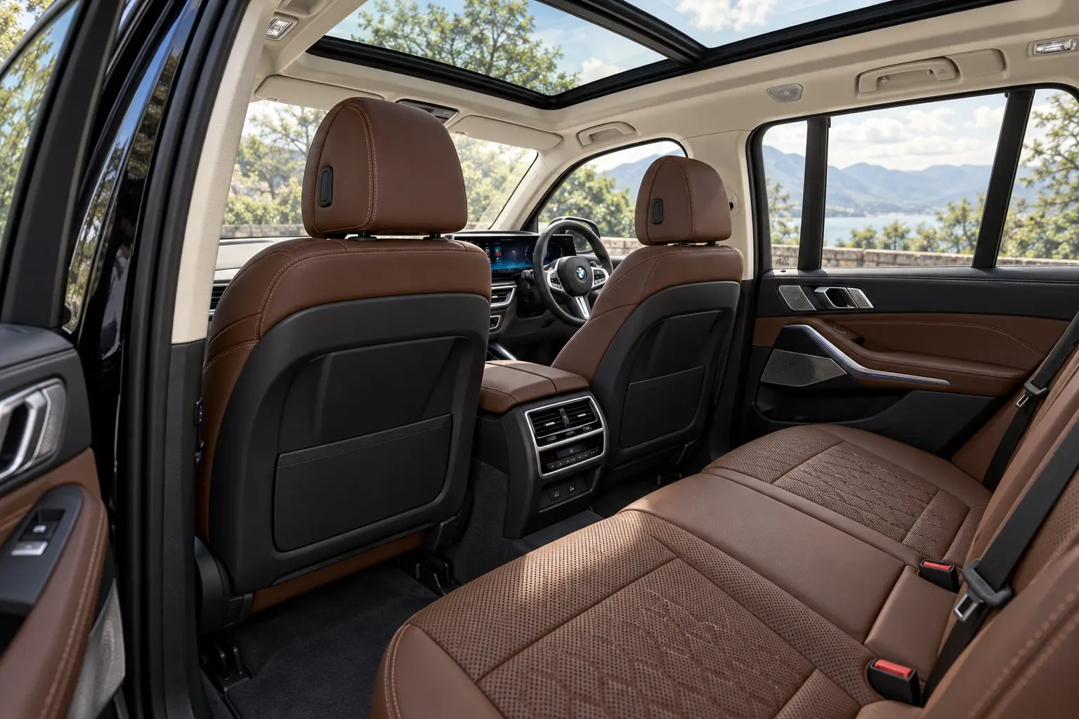 BMW X5（G05型）の前席と後席の実車イラスト。茶色のレザーシート、ガラスルーフからの光、横長の曲面ディスプレイ、広い後席