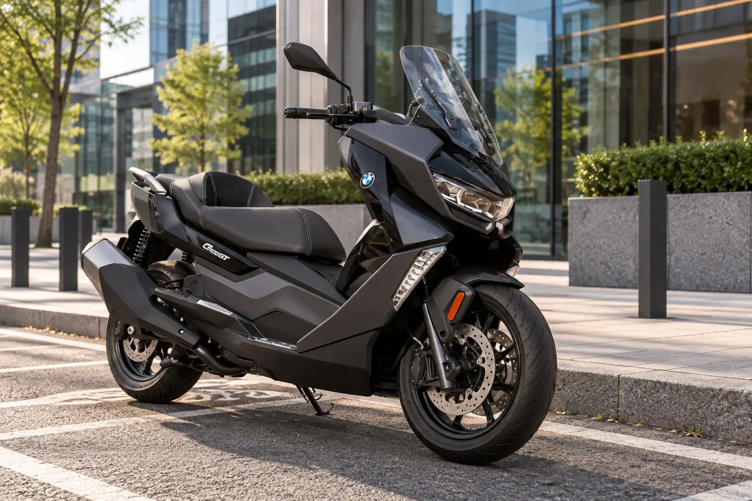 BMW C 400 GTを斜め前から見たカット。黒い大きなスクーターの車体、鋭いLEDヘッドライト、背の高いスクリーン、段の付いたシート、前15インチ・後14インチのホイール