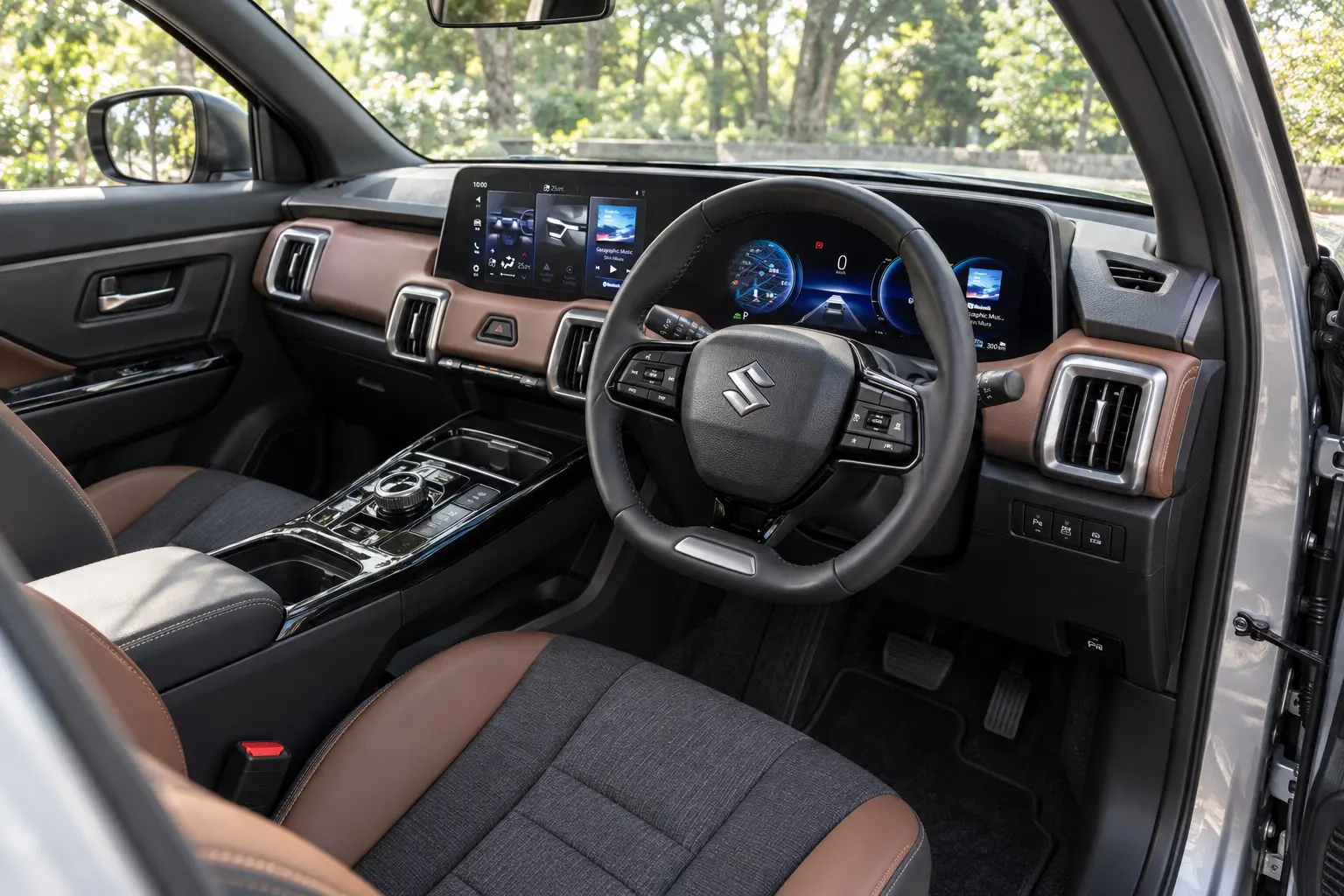 スズキ e ビターラの運転席側から見た室内。メーターとセンターの2枚のディスプレイが横につながったインパネ、ブラックとブラウンの内装。窓の外は木立、昼の自然光