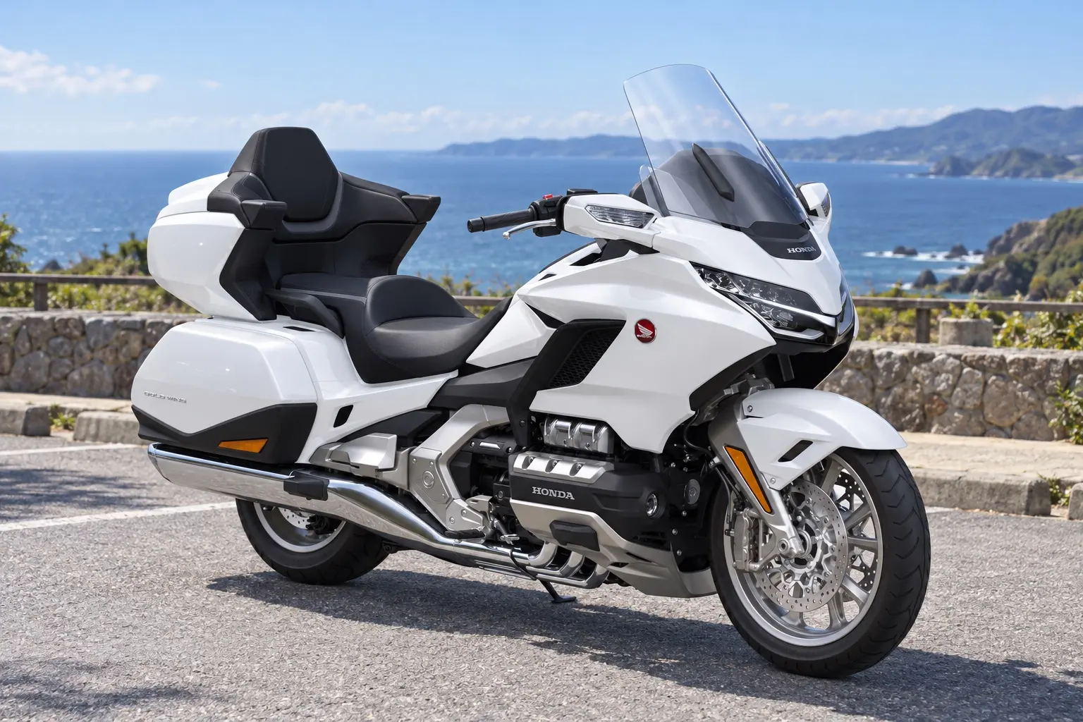 ホンダ Gold Wing Tourを斜め前から見たカット。白い大きなフルカウル、横に広いLEDヘッドライト、背の高いスクリーン、後ろの大きなトランクと左右のサドルバッグ、幅の広いハンドル