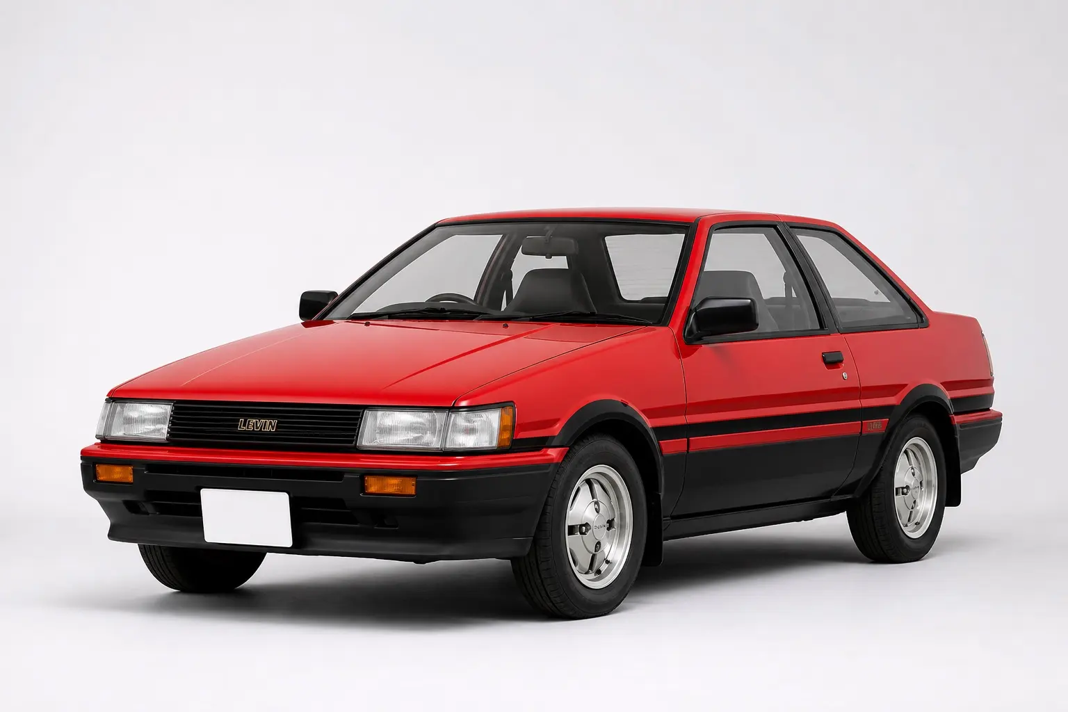 1983年式 トヨタ カローラレビン（AE86型）3ドアの斜め前からの外観。白と黒のツートン、固定式の角型ヘッドランプ、当時のスチールバンパー。背景は白い無地のスタジオ