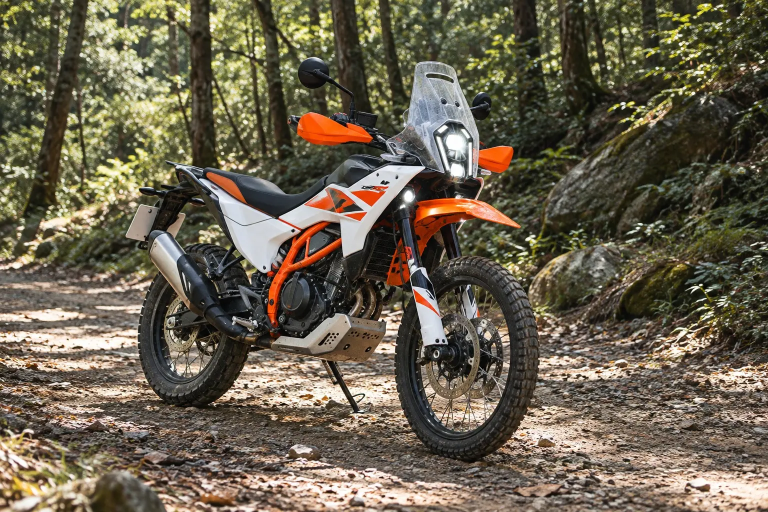 KTM 390 ADVENTURE Rを斜め前から見たカット。白とオレンジの外装、縦長のLEDヘッドライト、短いスクリーン、前21インチのスポークホイール、高いシート