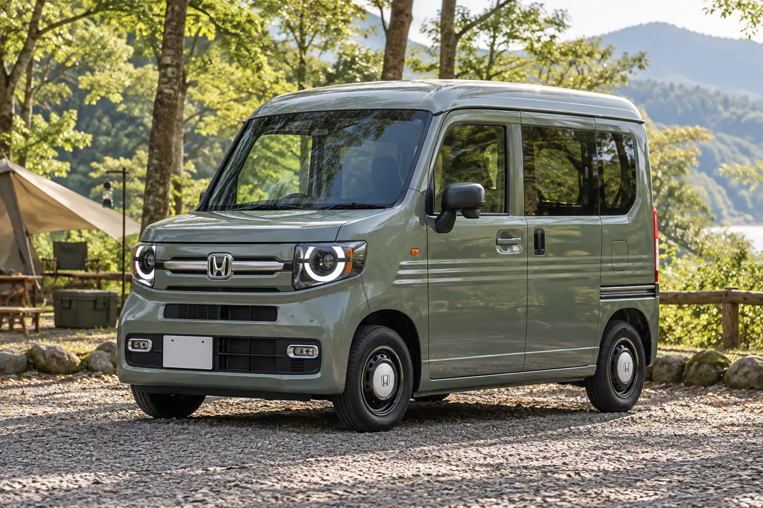 ホンダ N-VAN FUNの斜め前からの外観。丸いフルLEDヘッドライト、背の高い四角いボディ、2トーンのフルホイールキャップ。ボディカラーはボタニカルグリーン・パール。キャンプ場の砂利の駐車場に停まっている