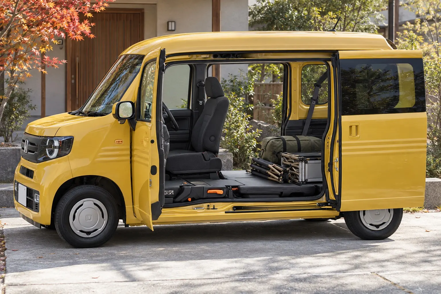 ホンダ N-VANの助手席側。前のドアと後ろのスライドドアを両方開けて、柱の無い大きな開口部から、折りたたんだキャンプ道具を積み込んでいるカット。助手席は床まで倒してある。ボディカラーはオータムイエロー・パール