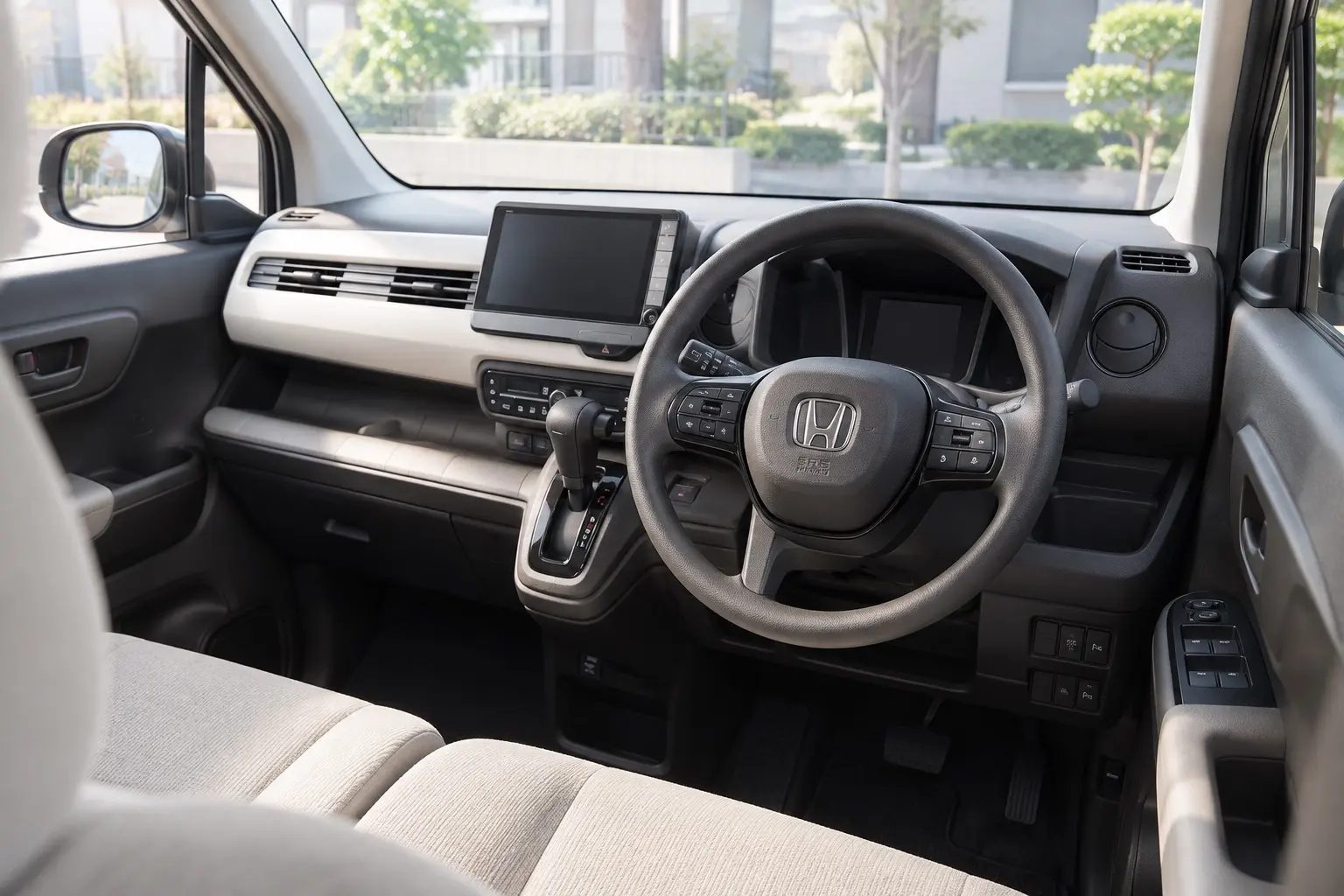 ホンダ N-WGNの運転席まわり。シンプルな水平基調のダッシュボード、7インチの液晶メーター、ハンドル右側のクルーズコントロールのスイッチ、ジャージー素材のベージュのシートが見えるカット