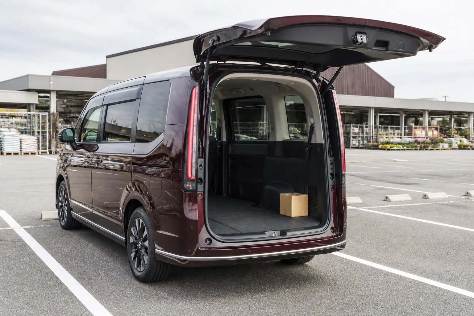 ホンダ ステップ ワゴン SPADAを斜め後ろから捉えた外観カット。テールゲートを開けて、平らな荷室の床が見えている