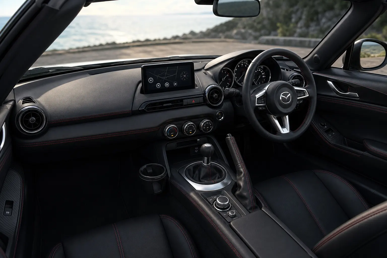マツダ ロードスターの運転席まわりのインテリア。赤いステッチの入った黒基調。ステアリング、シフトレバー、8.8インチのセンターディスプレイが見える