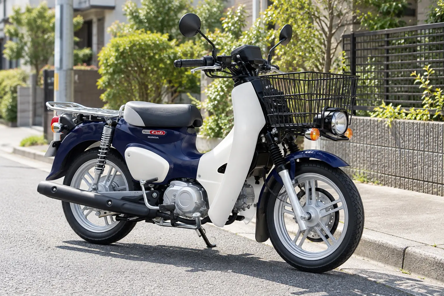 ホンダ スーパーカブ110 プロ Liteを斜め前から見たカット。紺色の車体、前の大きなかご、後ろの大きな荷台