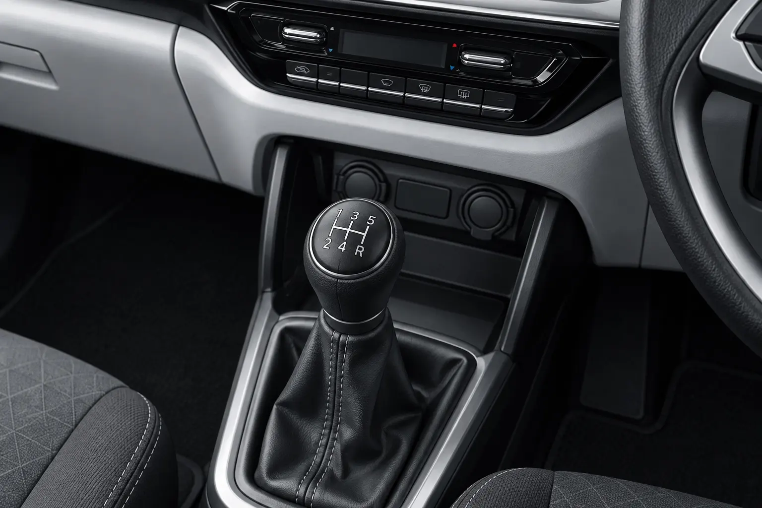 スズキ スイフト HYBRID MX 5MT車のセンターコンソール。5速のシフトパターンが刻まれたシフトノブと、その奥の空調スイッチが分かるカット