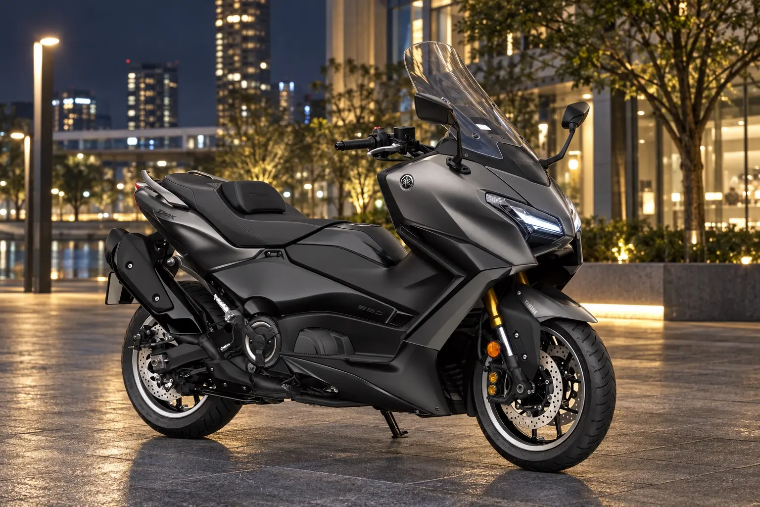 ヤマハ TMAX560 TECH MAXを斜め前から見たカット。つや消しの濃いグレーの車体、鋭い目つきのLEDヘッドライト、背の高いスクリーン、低く長いシート、切削加工の15インチのホイール
